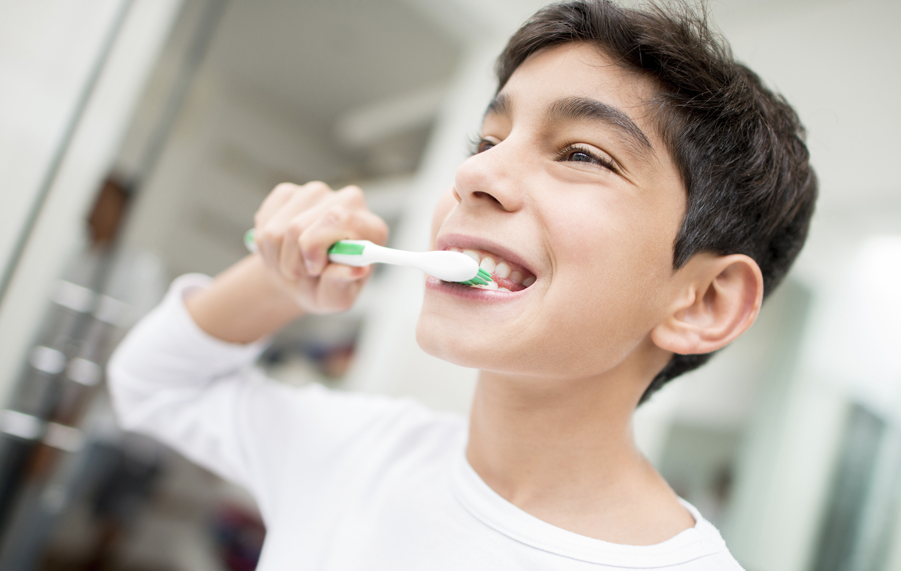 AltaMed tween boy in white shirt brushing teeth