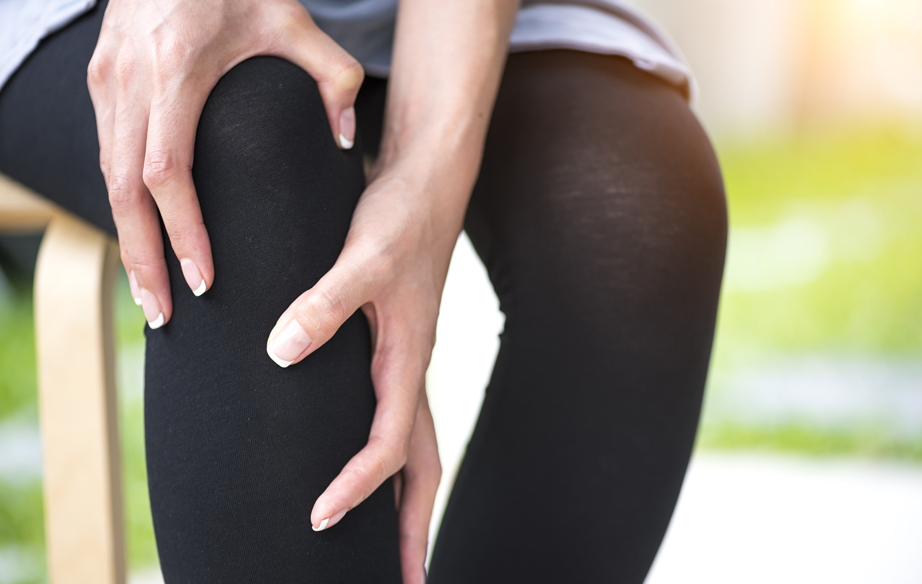 AltaMed woman holding knee in pain