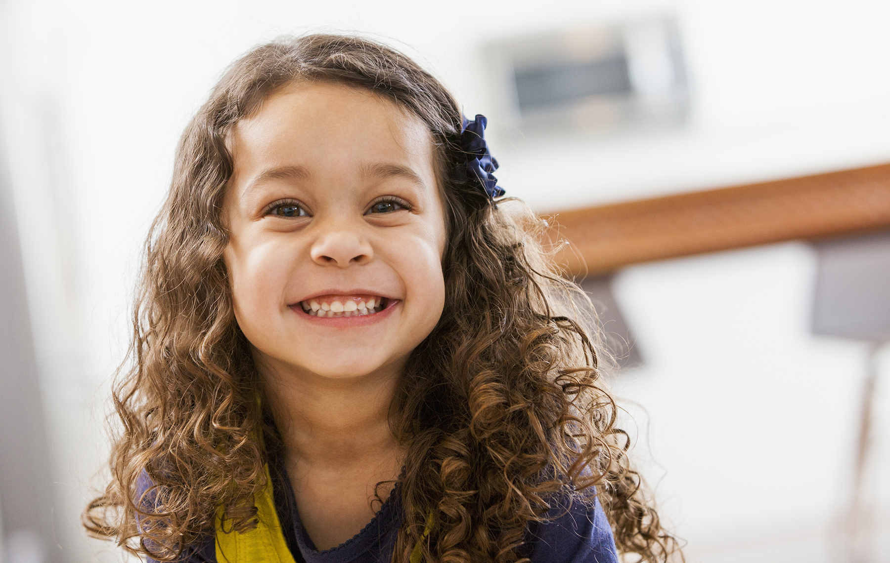 AltaMed Small girl with curls smiling showing teeth